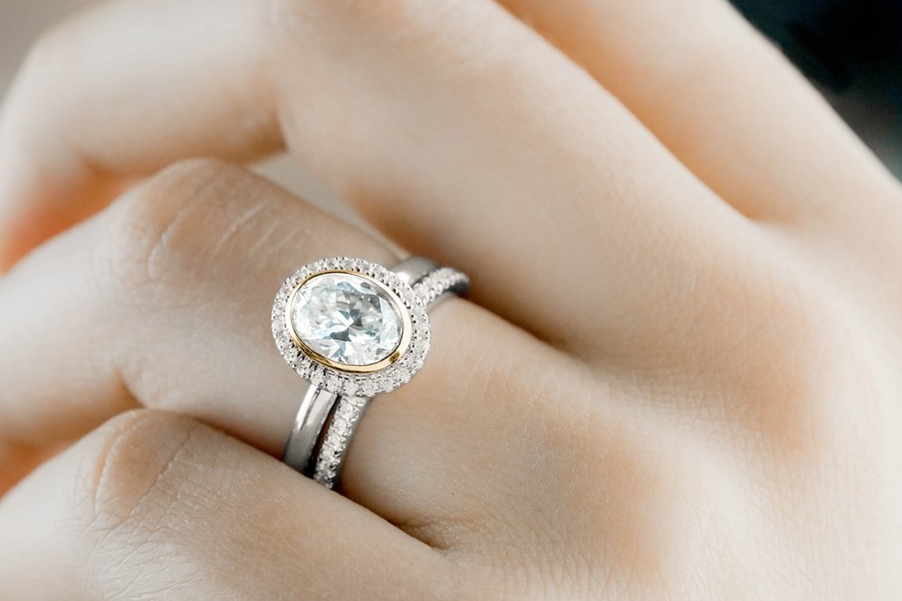 a woman’s hand wearing a diamond engagement ring by Noam Carver